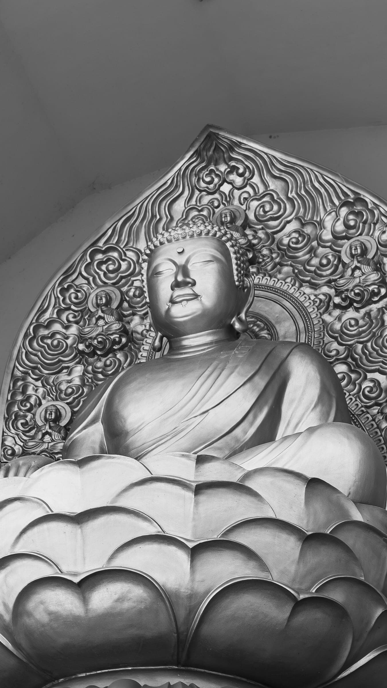 Black-and-white close-up of a seated Buddha statue on a lotus throne
